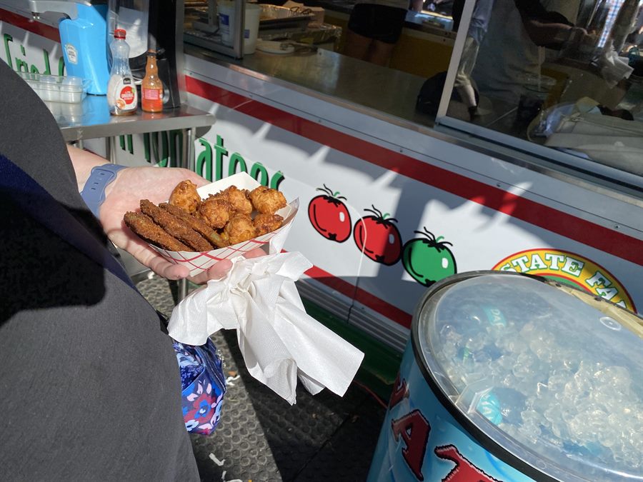 A fresh tray held in front of the stand itself, its red and green tomato logo visible